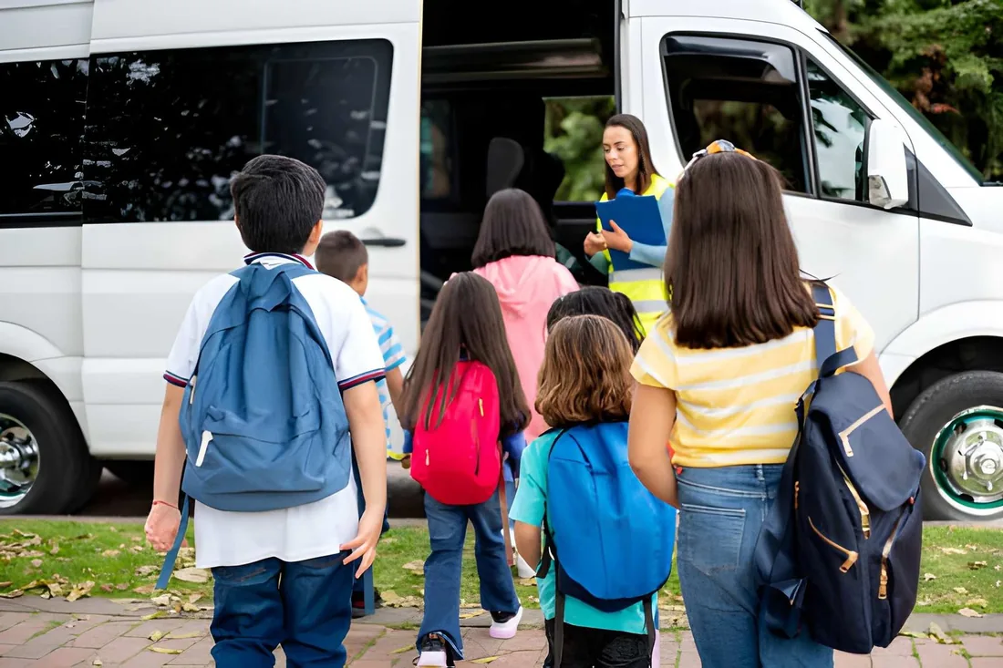 Children boarding a minibus with an adult supervisor